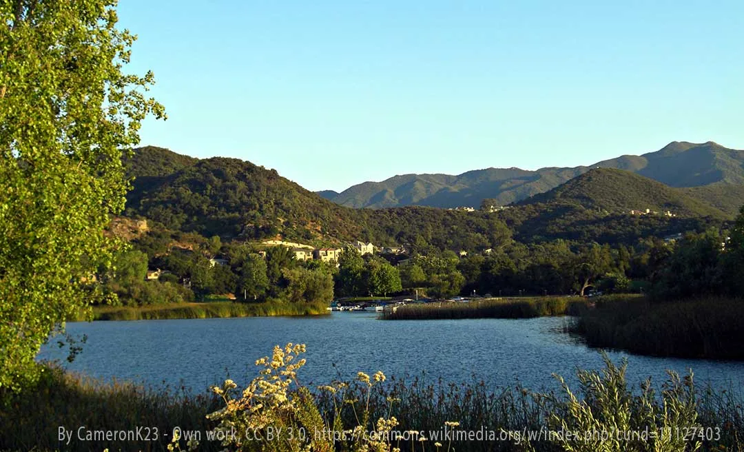 Lake Sherwood with calm water, reeds, and surrounding hills at sunset, service area for a Plumber in Lake Sherwood, CA.