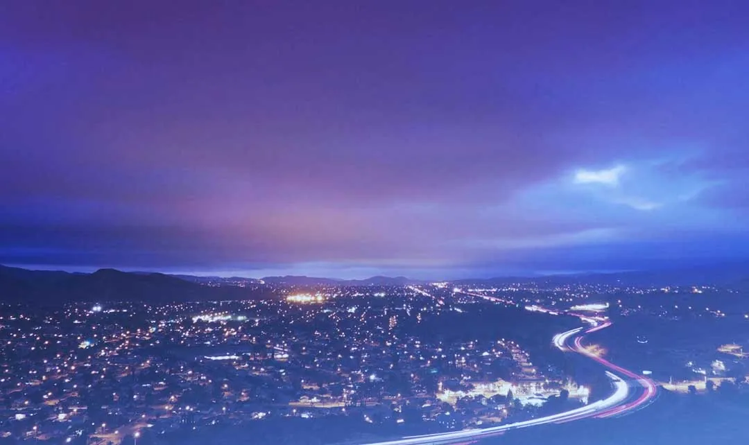 Nighttime view of Simi Valley, CA with city lights and winding freeway, service area for plumber in Simi Valley