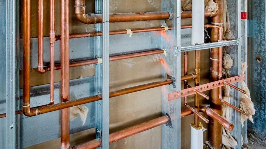 Commercial pipe repair and replacement Santa Barbara – copper plumbing pipes exposed in metal wall framing, commercial building service.